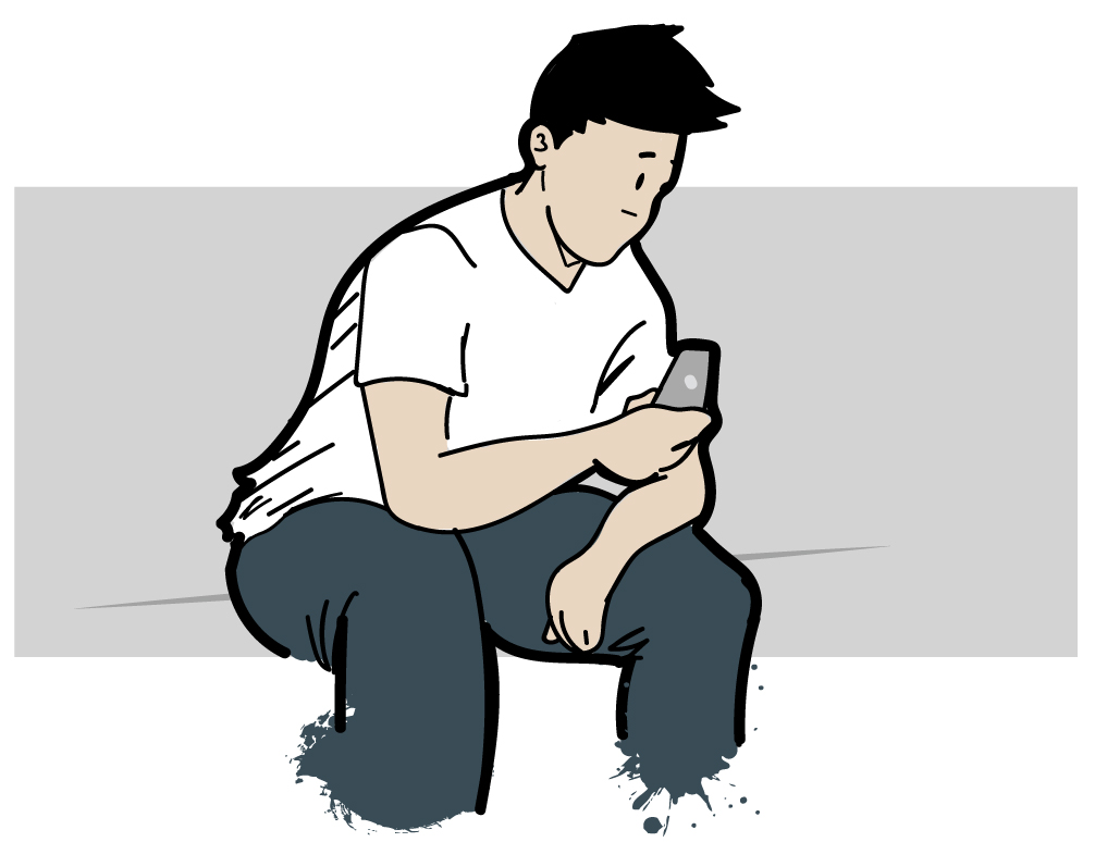 Man sitting while looking at his mobile phone